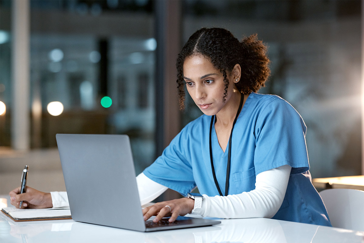 Orthopedic healthcare professional analyzing data on a laptop in a modern office setting